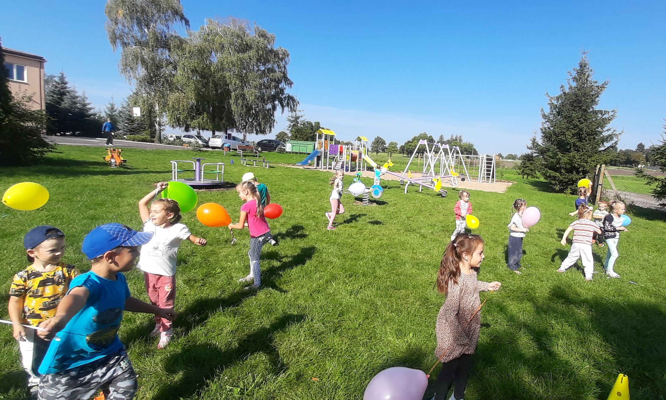 Przedszkolaki bawią się balonami na świeżym powietrzu