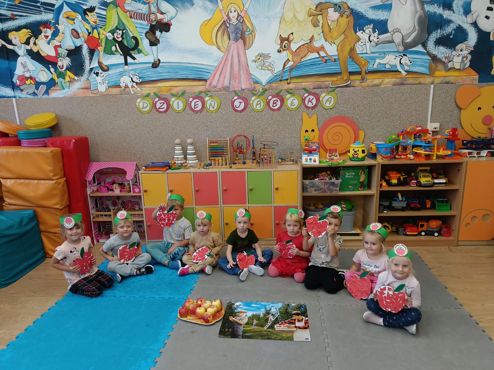 Przedszkolaki prezentują swoje prace plastyczne w kształcie jabłek