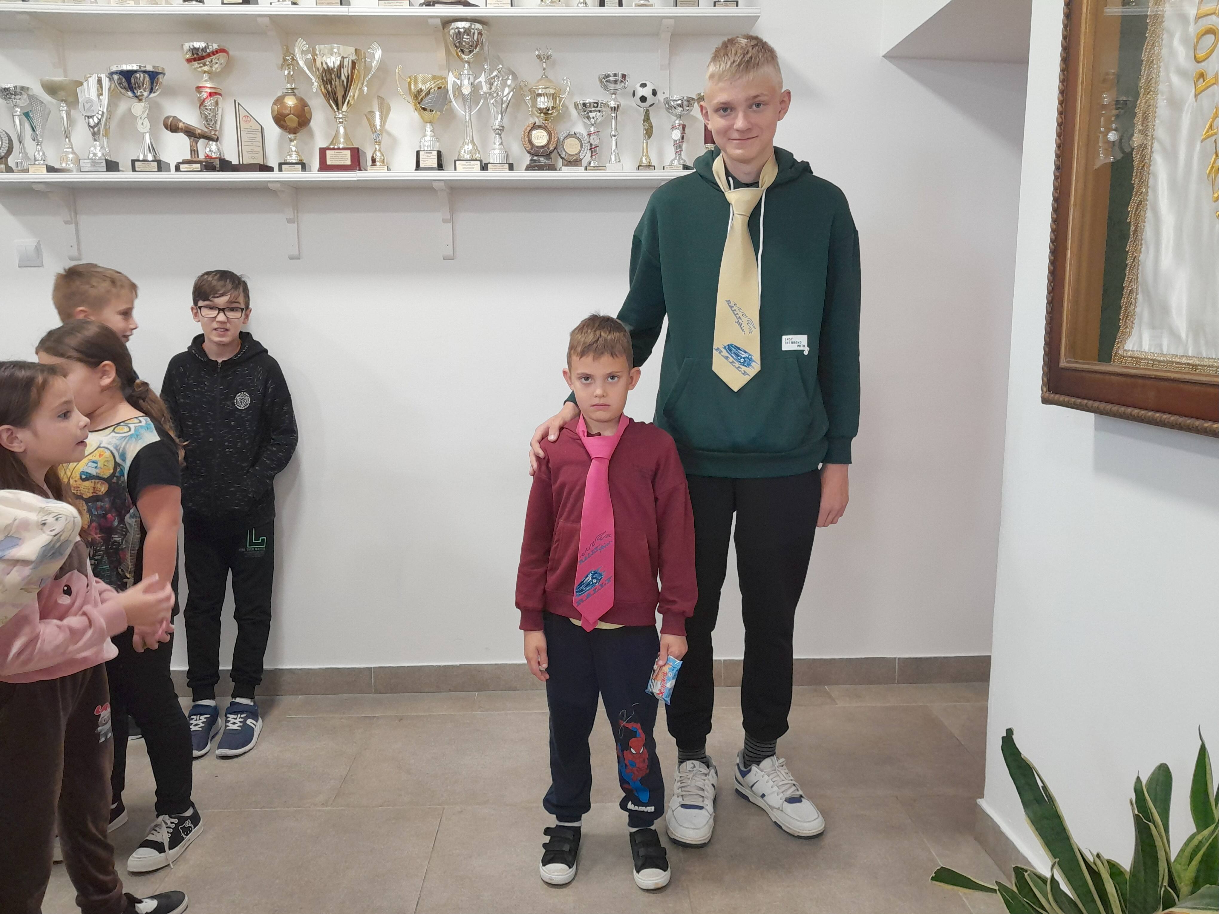 Dwaj najsympatyczniejsi chłopcy w szkole przed grupą pozostałych uczniów szkoły