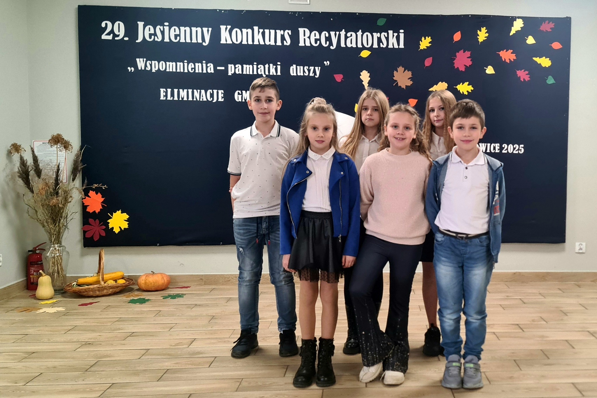 Cztery dziewczynki i dwóch chłopców - uczestnicy konkursu z naszej szkoły na tle tablicy dekoracyjnej