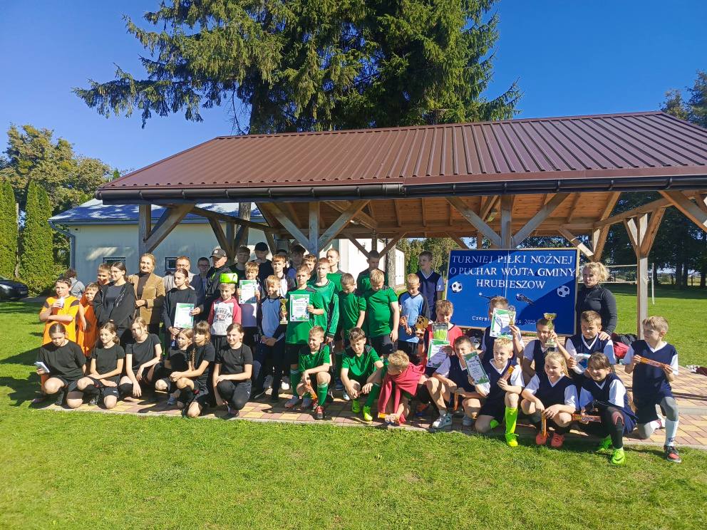 Uczestnicy turnieju piłkarskiego na tle tablicy dekoracyjnej