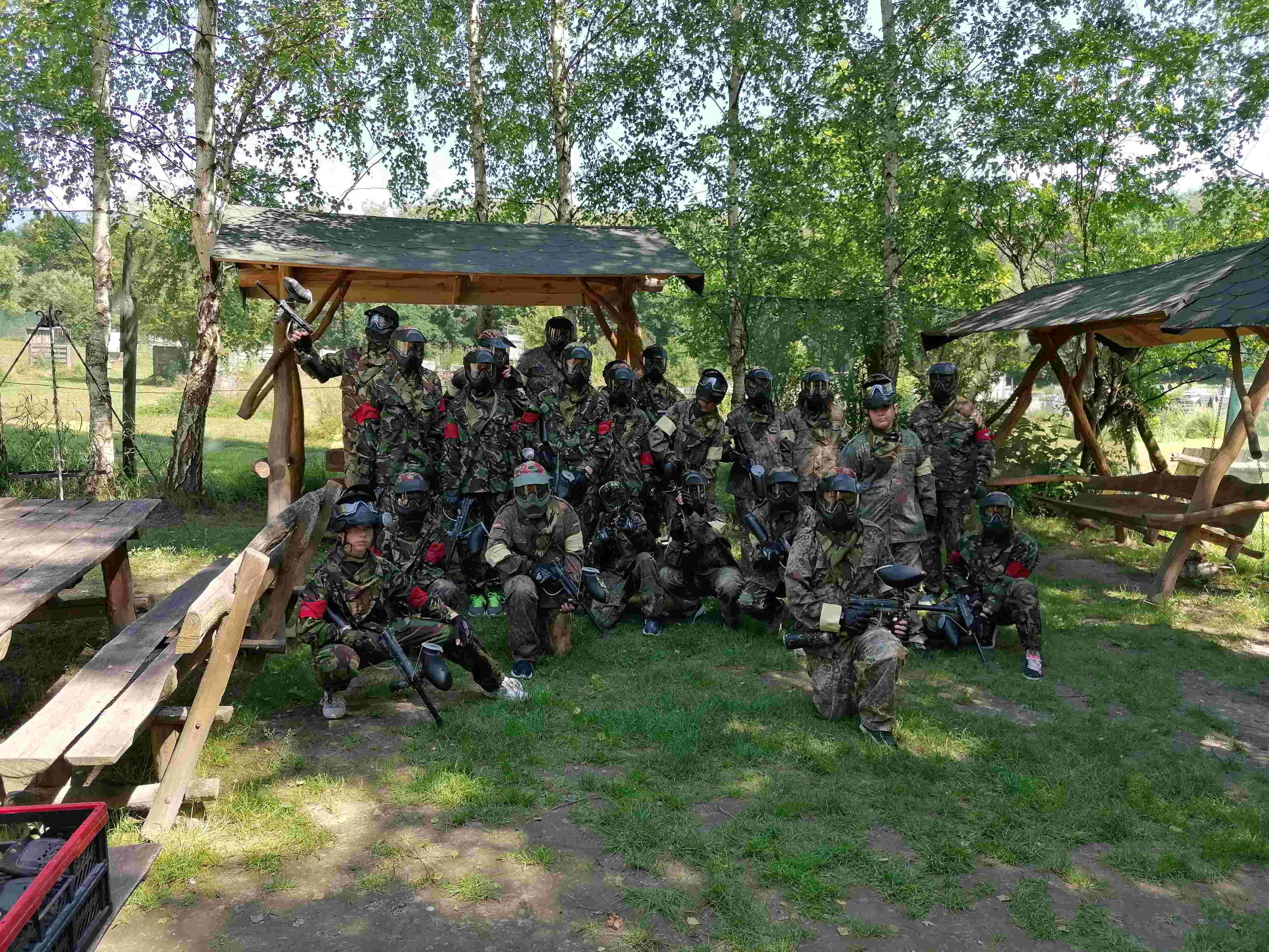 Grupa uczniów z nauczycielami przebrana w stroje do gry w paintball