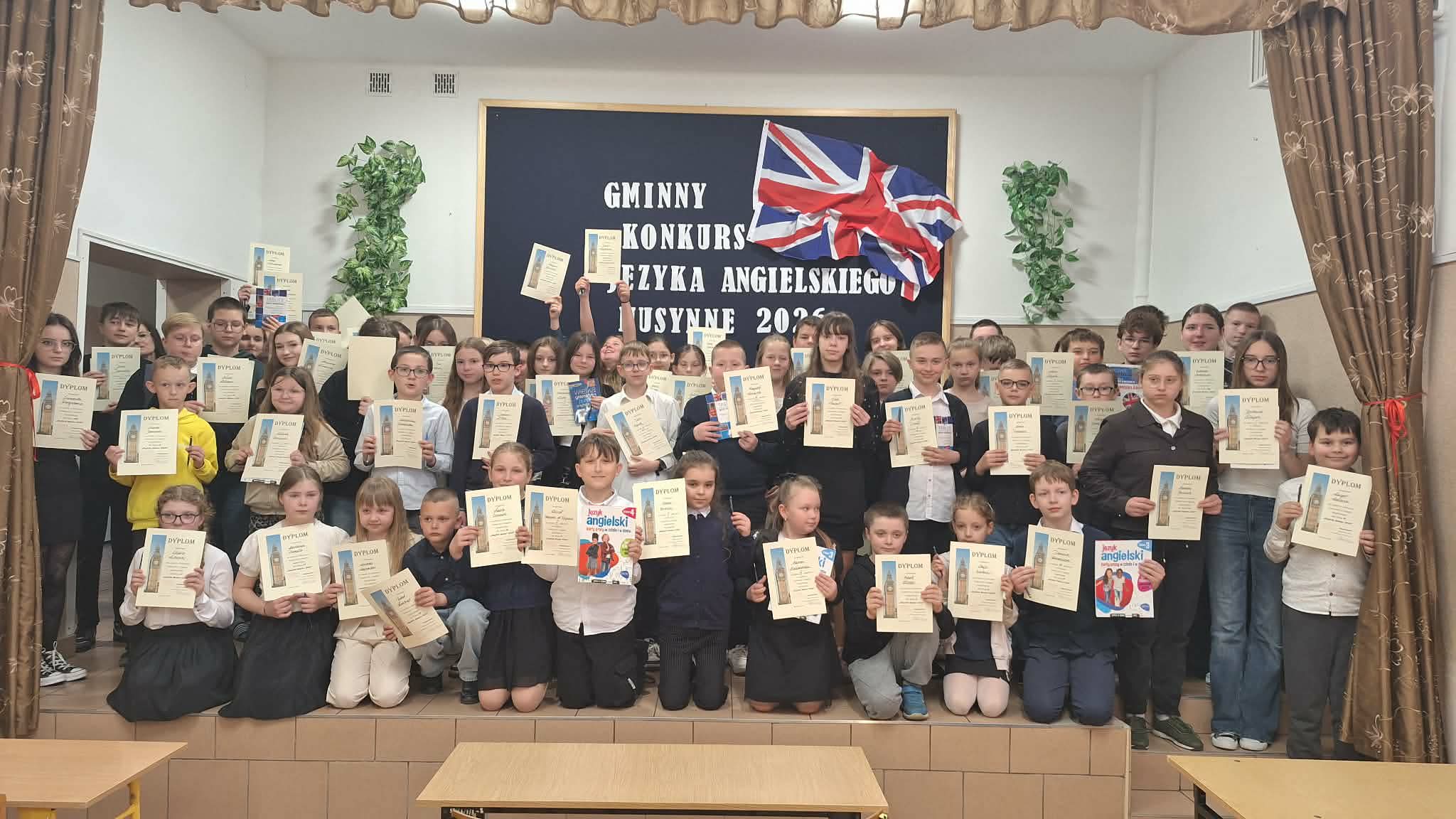 Grupowe zdjęcie uczestników Gminnego Konkursu Języka Angielskiego z dyplomami, wykonane na zakończenie wydarzenia.