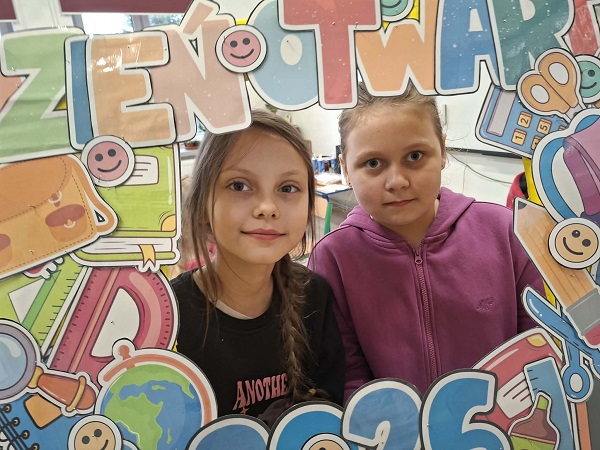 Grafika ilustrująca dziewczynki z fotoramką