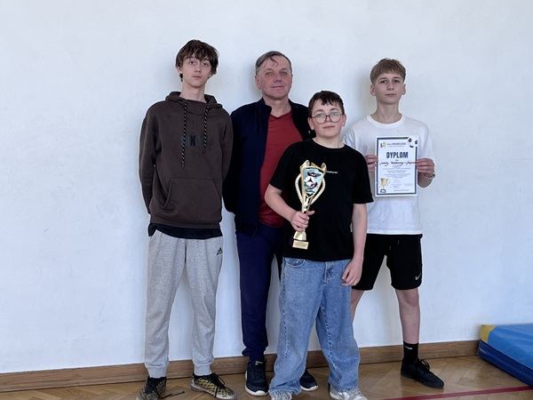 Grafika ilustrująca uczestników turnieju z trenerem