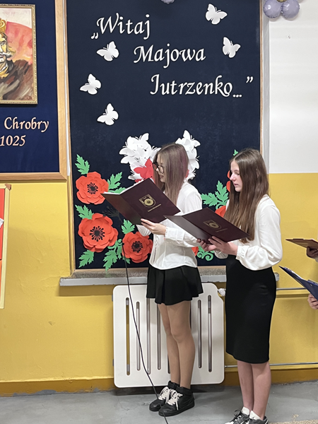 Grafika ilustrująca uczennice podczas akademii