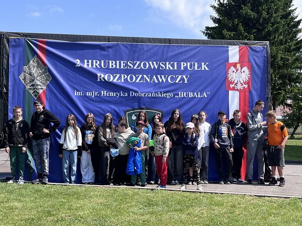 Grafika ilustrująca uczniów podczas wizyty w wojsku