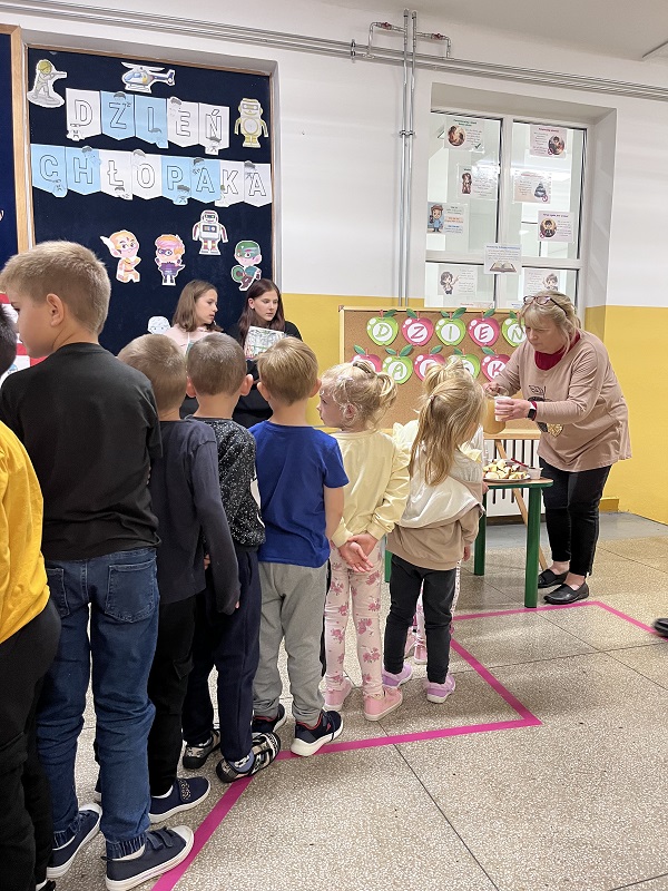 Grafika ilustrująca dzieci podczas jabłkowego poczęstunku