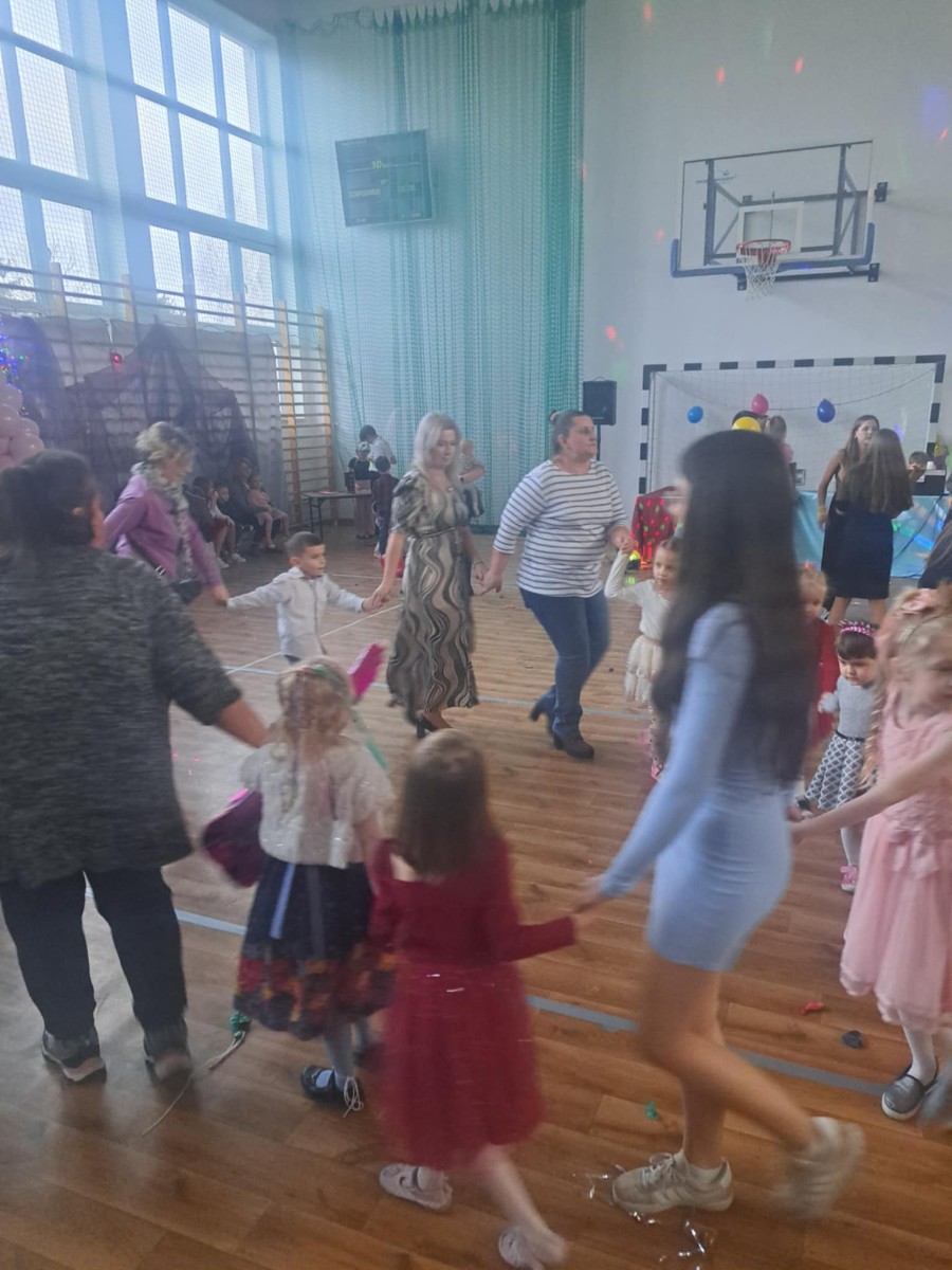 Dzieci biorą udział w zabawach tanecznych z całą społecznością szkolną.