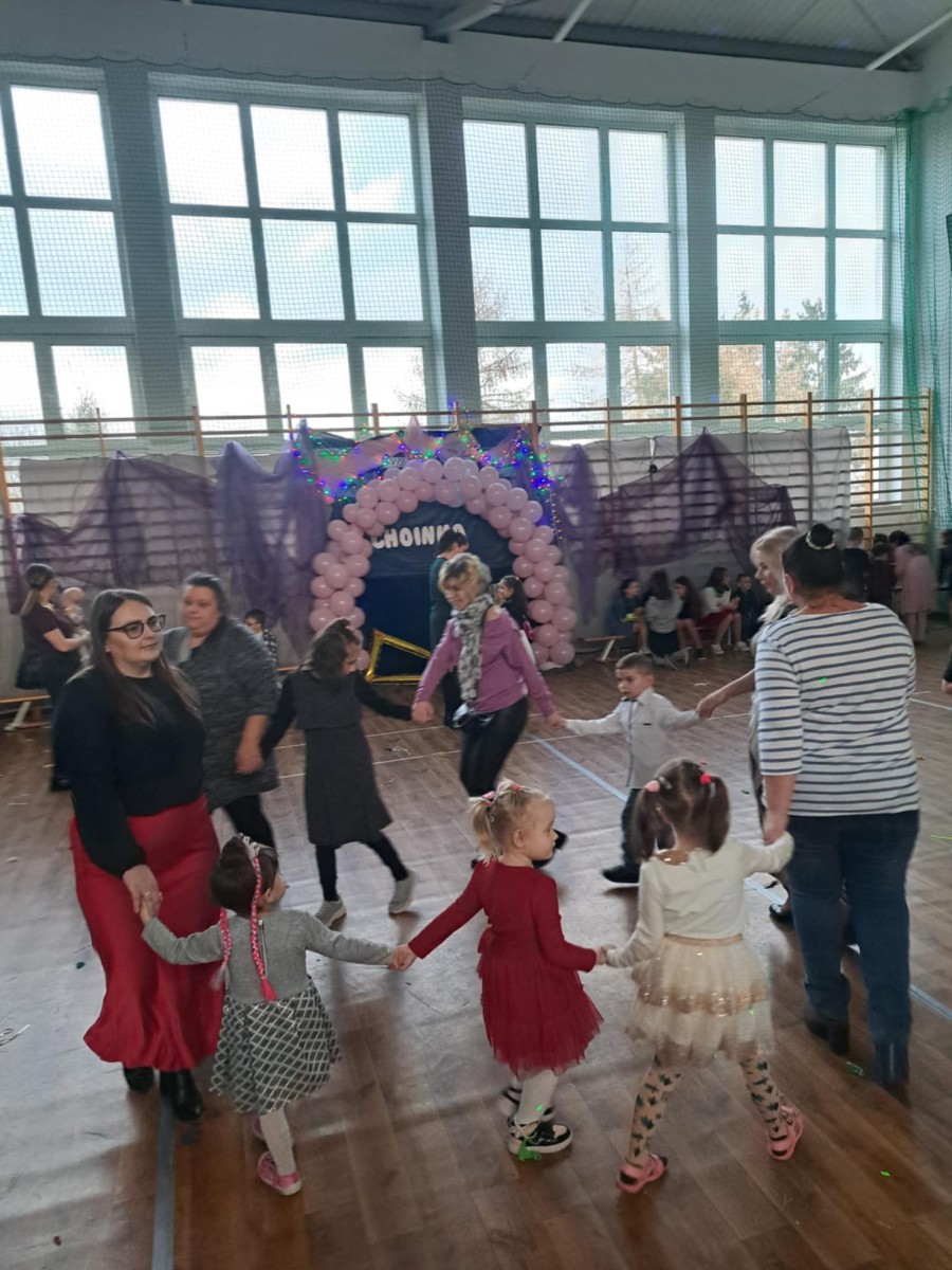 Dzieci biorą udział w zabawach tanecznych z całą społecznością szkolną.