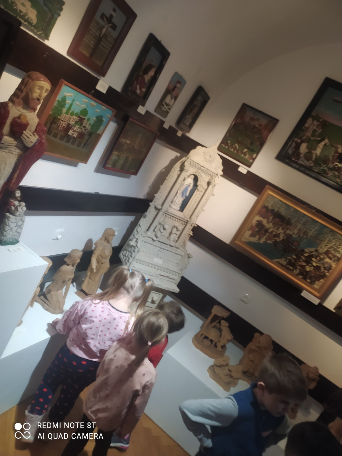 Dzieci oglądają eksponaty w muzeum.
