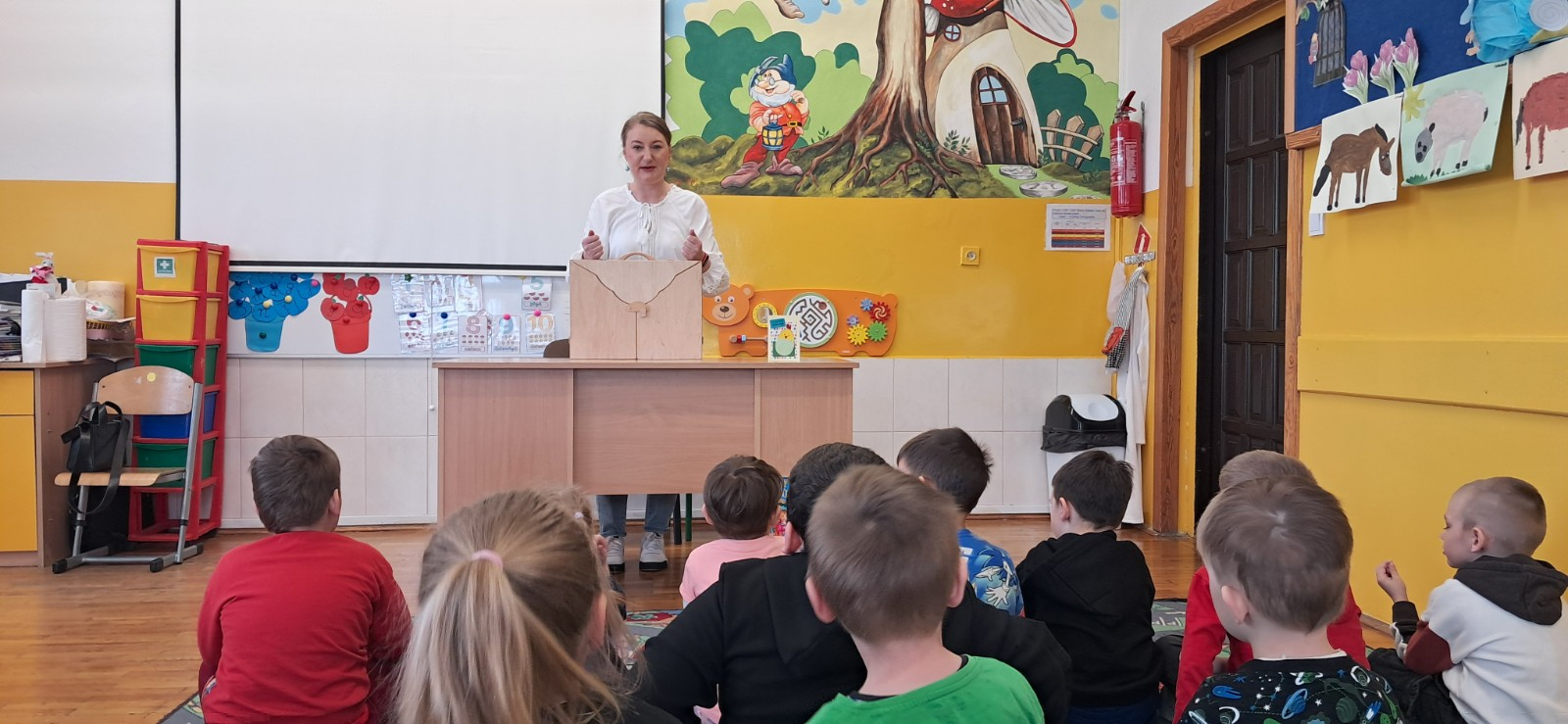 Dzieci oglądają teatrzyk Kamishibai.