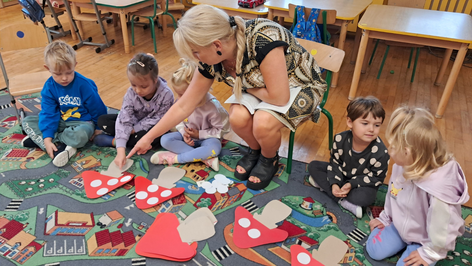 Dzieci przeliczają kropki na muchomorach.