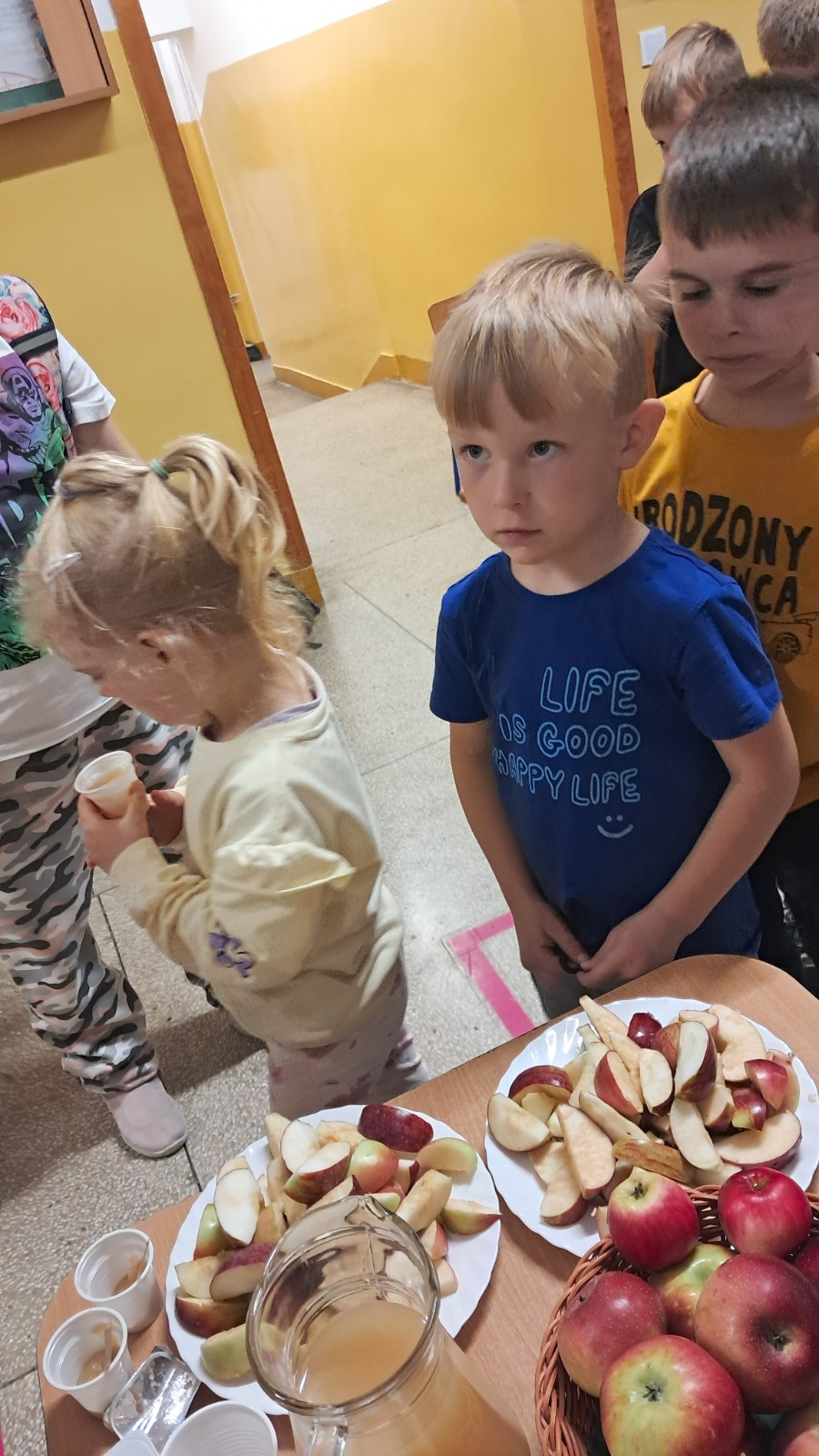 Dzieci degustują jabłka i sok z jabłek.