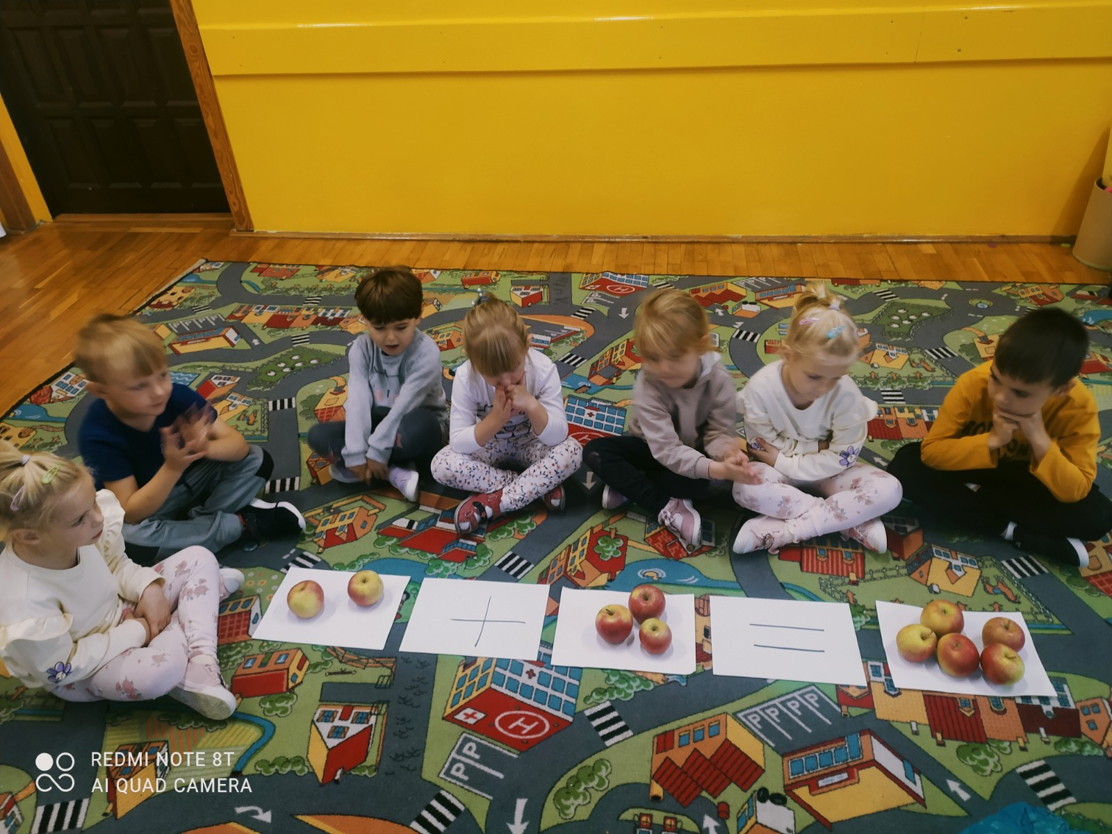 Dzieci przeliczają jabłka.