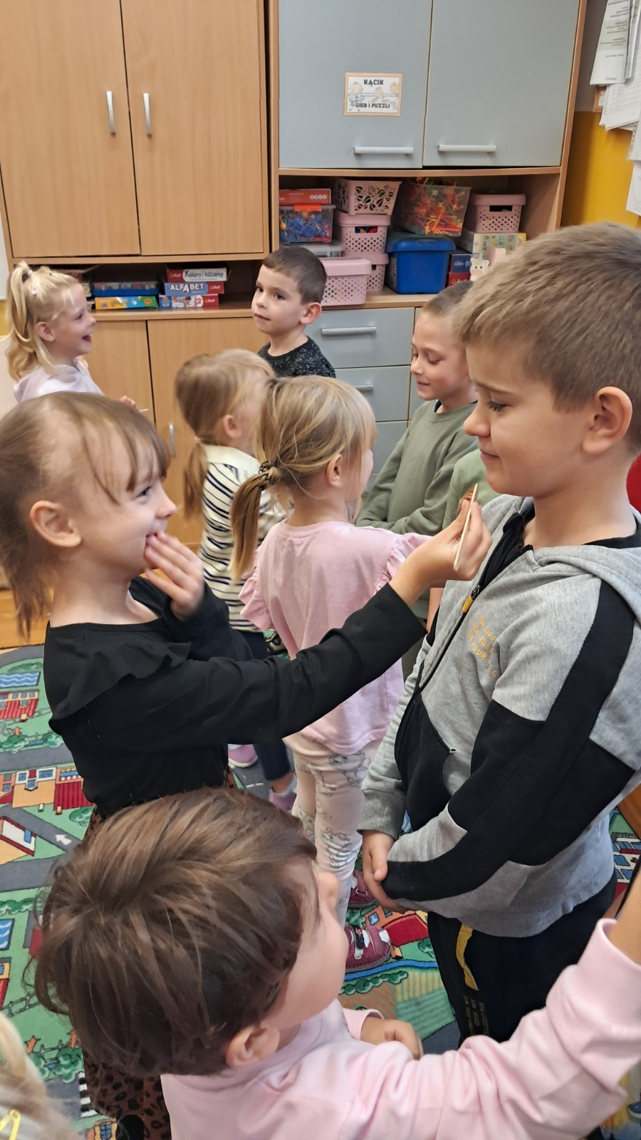 Dziewczynki golą brody chłopcom za pomocą drewnianego patyczka