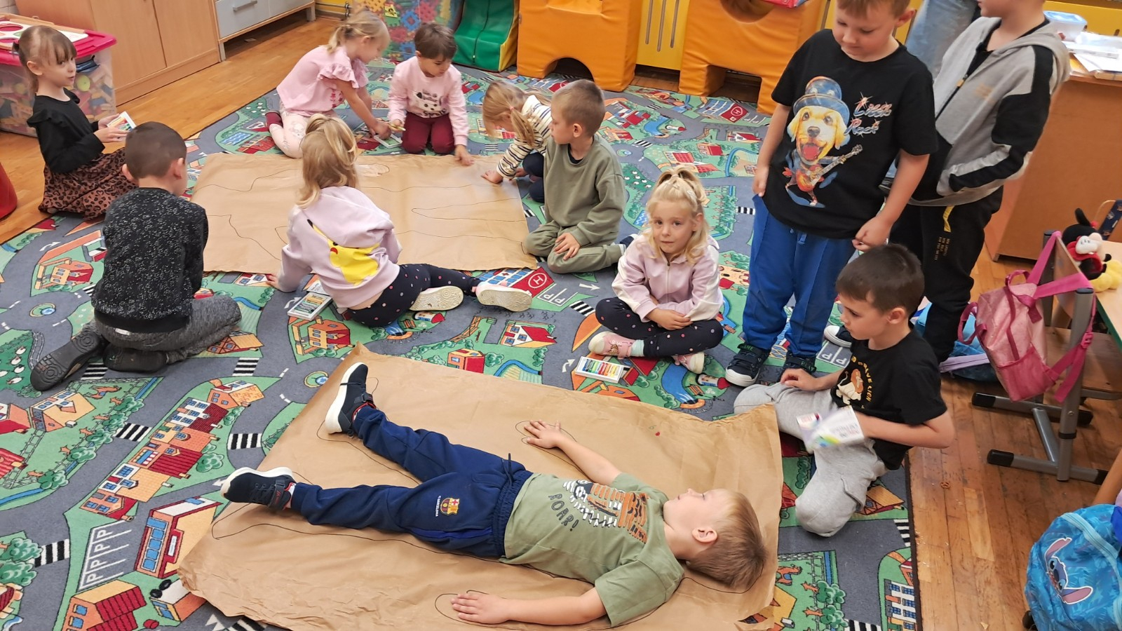 Dzieci odrysowują postać chłopca, a potem kolorują.