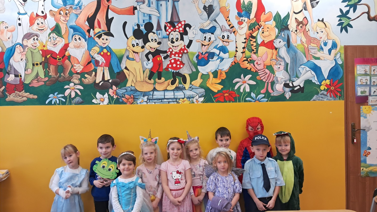 Dzieci prezentują się na tle bajkowych postaci.