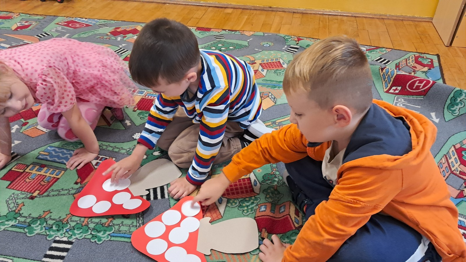 Dzieci przeliczają kropki na grzybie.