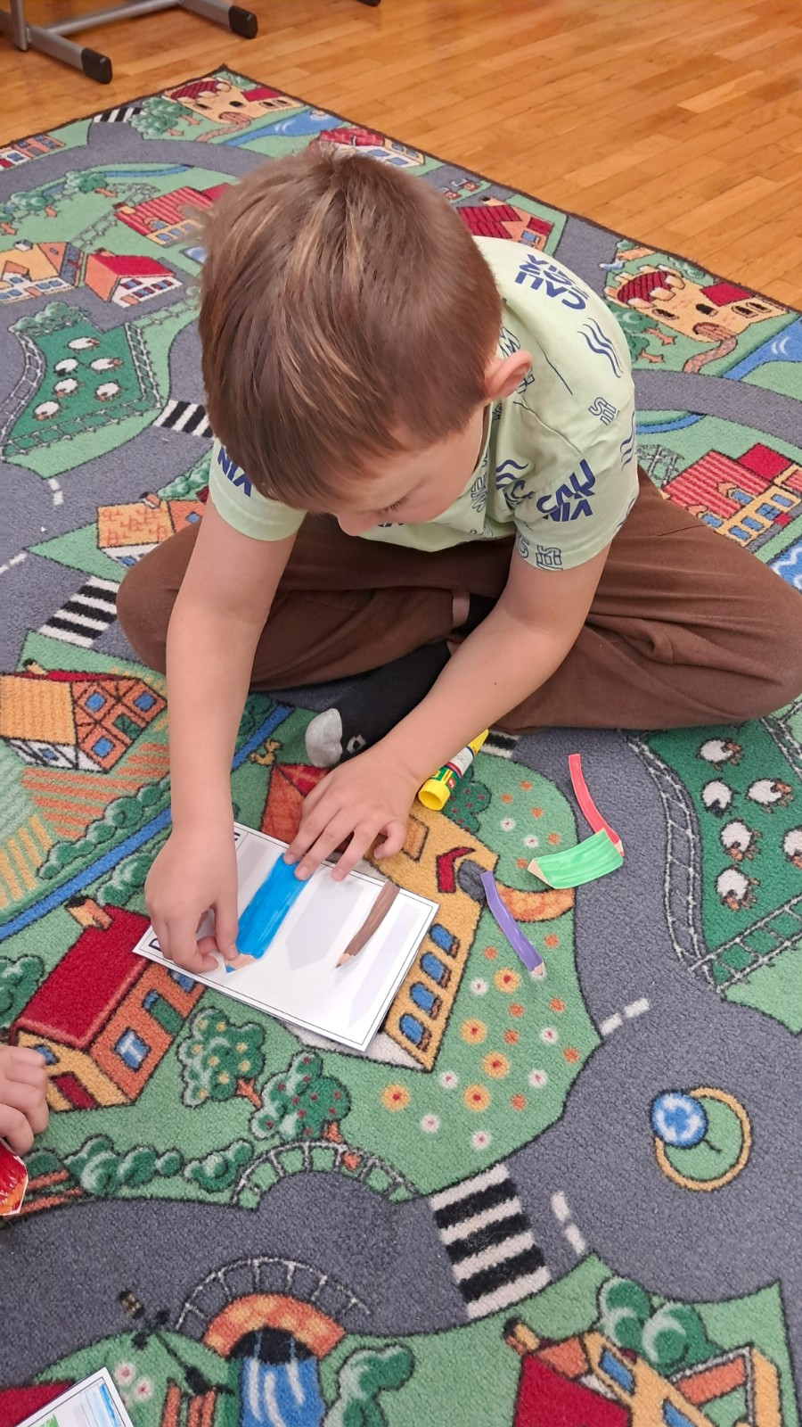 Chłopiec wykonuje pracę plastyczno-techniczną.