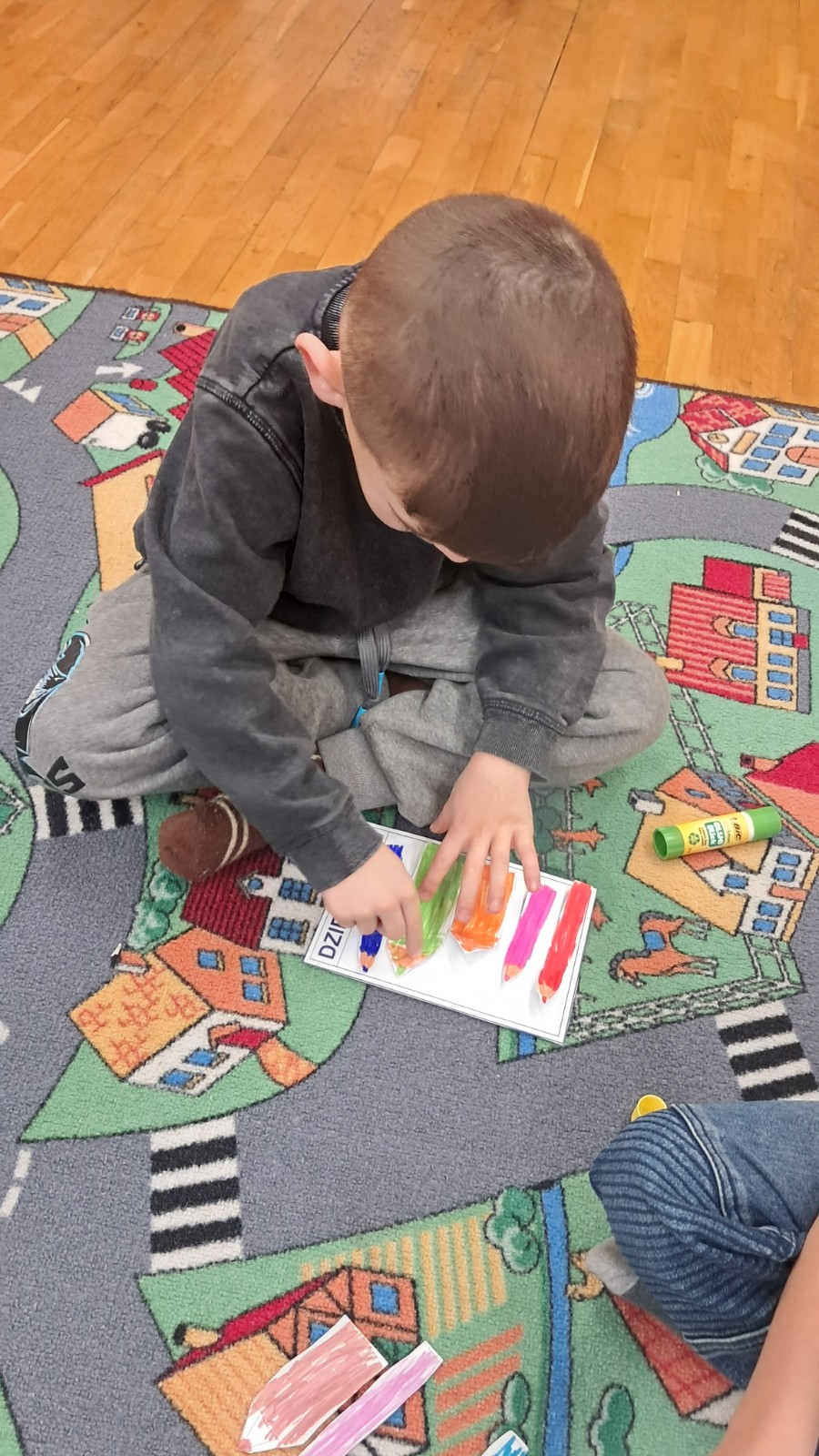 Chłopiec wykonuje pracę plastyczno-techniczną.