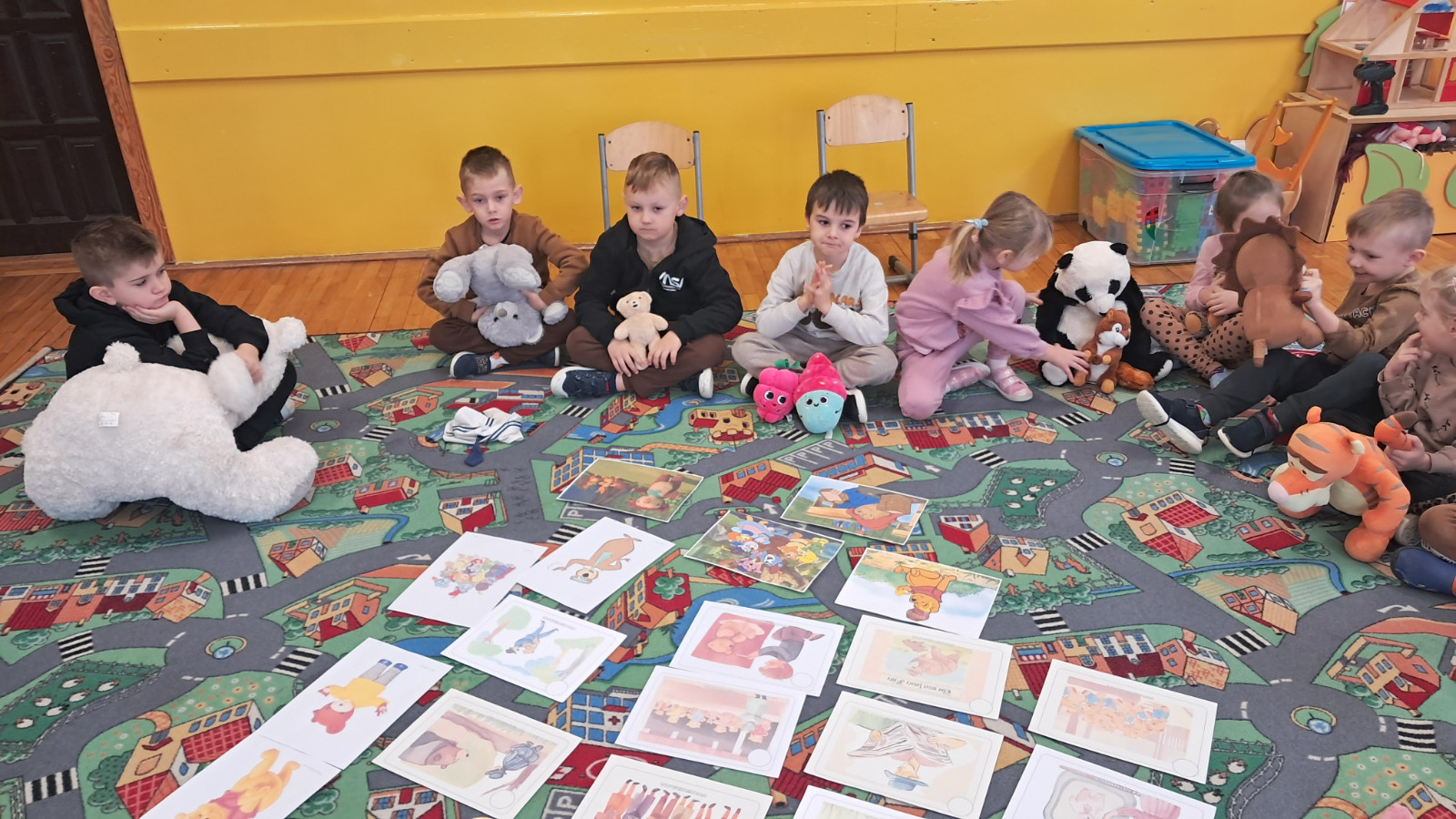 Dzieci słuchają historii o pluszowym misiu.