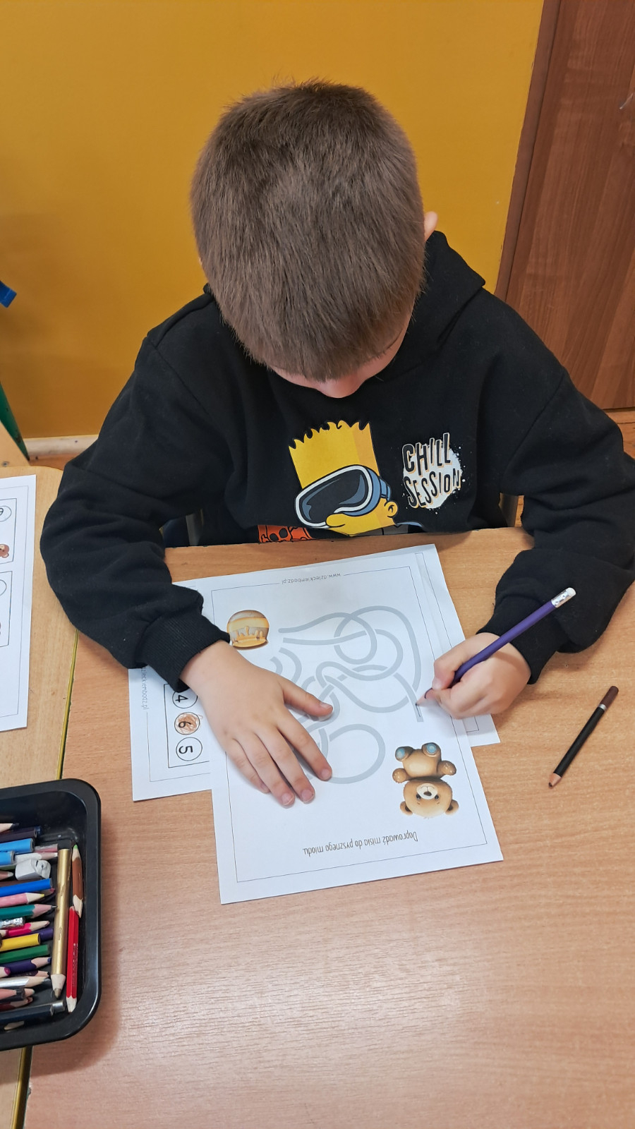 Dziecko wykonuje misiowe karty pracy.