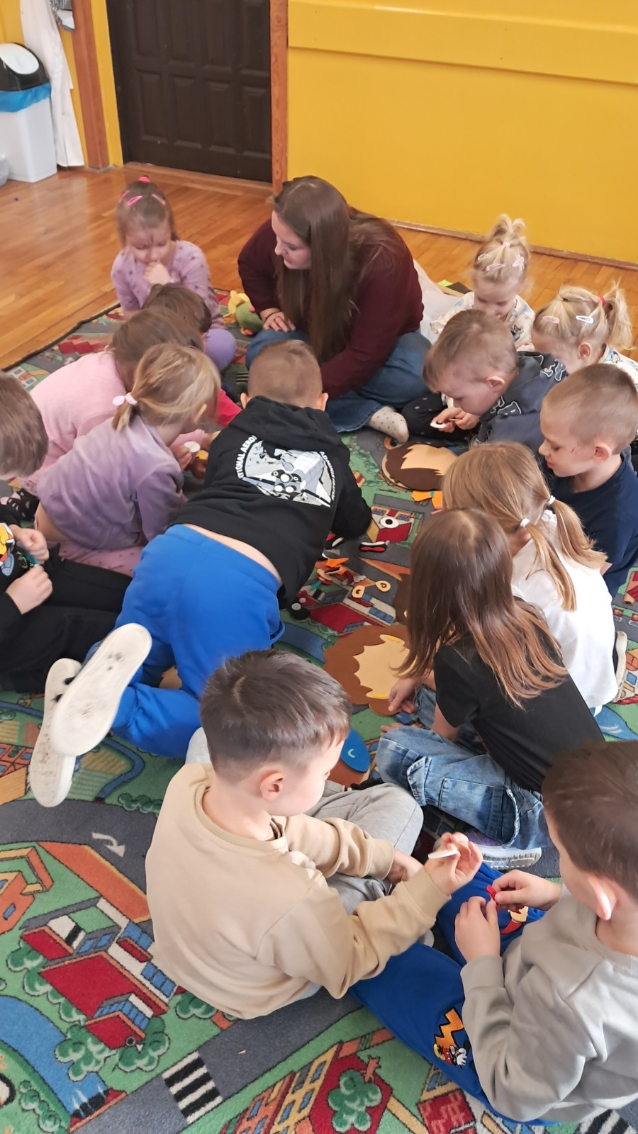 Dzieci biorą udział w zajęciach z Panią z poradni.