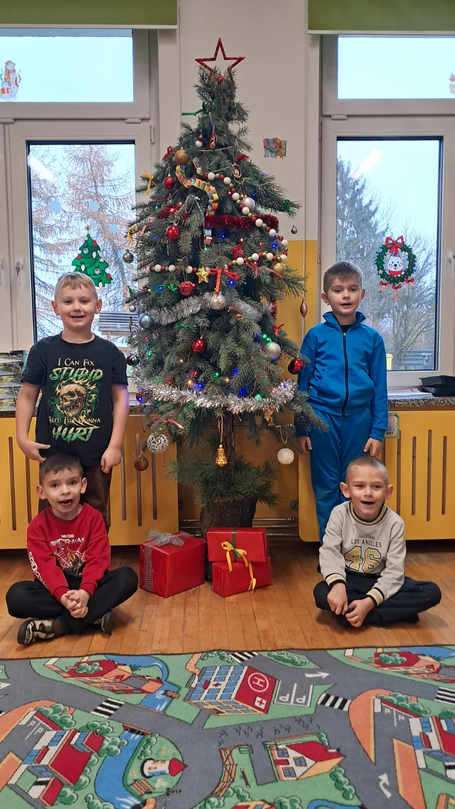 Chłopcy stoją przy choince.