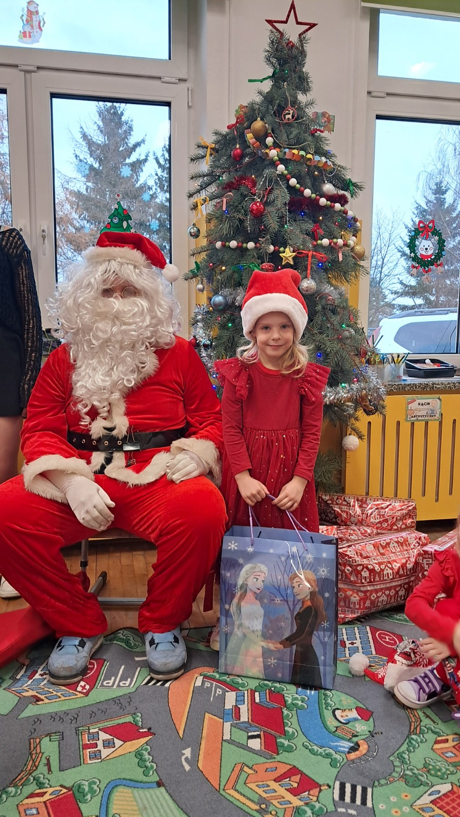 Dziecko pozuje do zdjęcia z Mikołajem.