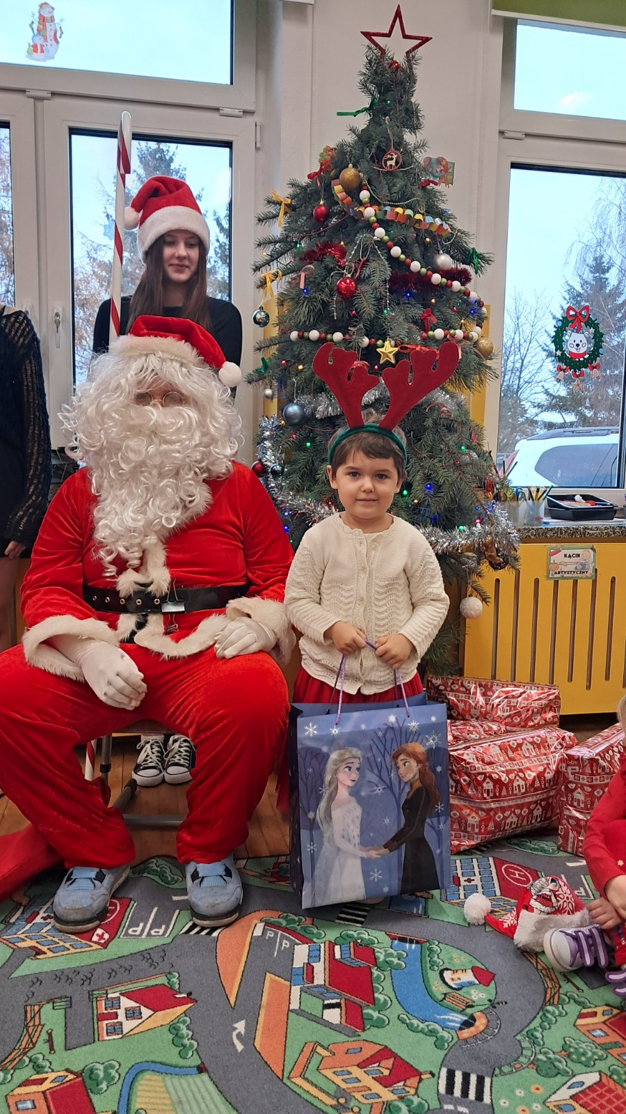 Dziecko pozuje do zdjęcia z Mikołajem.