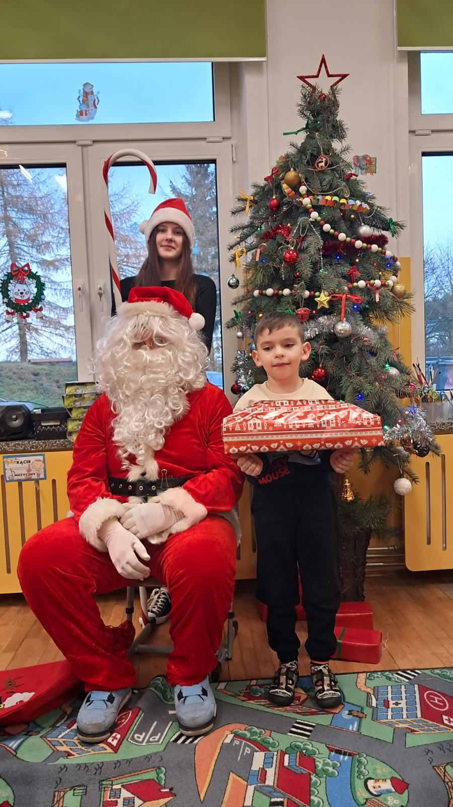 Dziecko pozuje do zdjęcia z Mikołajem.