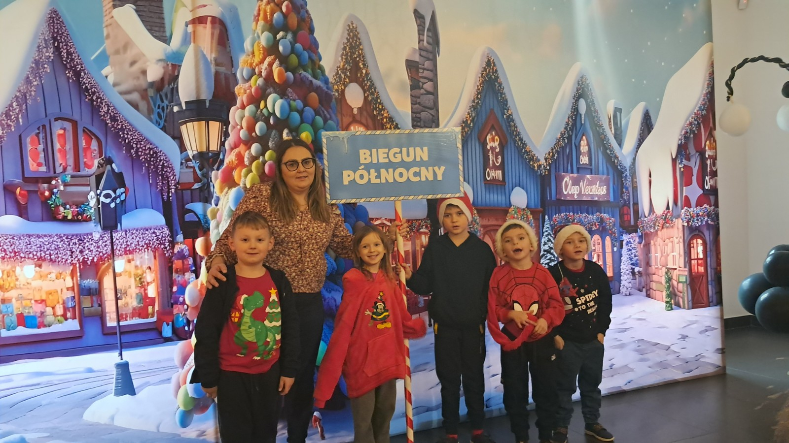 Dzieci pozują do zdjęcia w świątecznej scenerii.