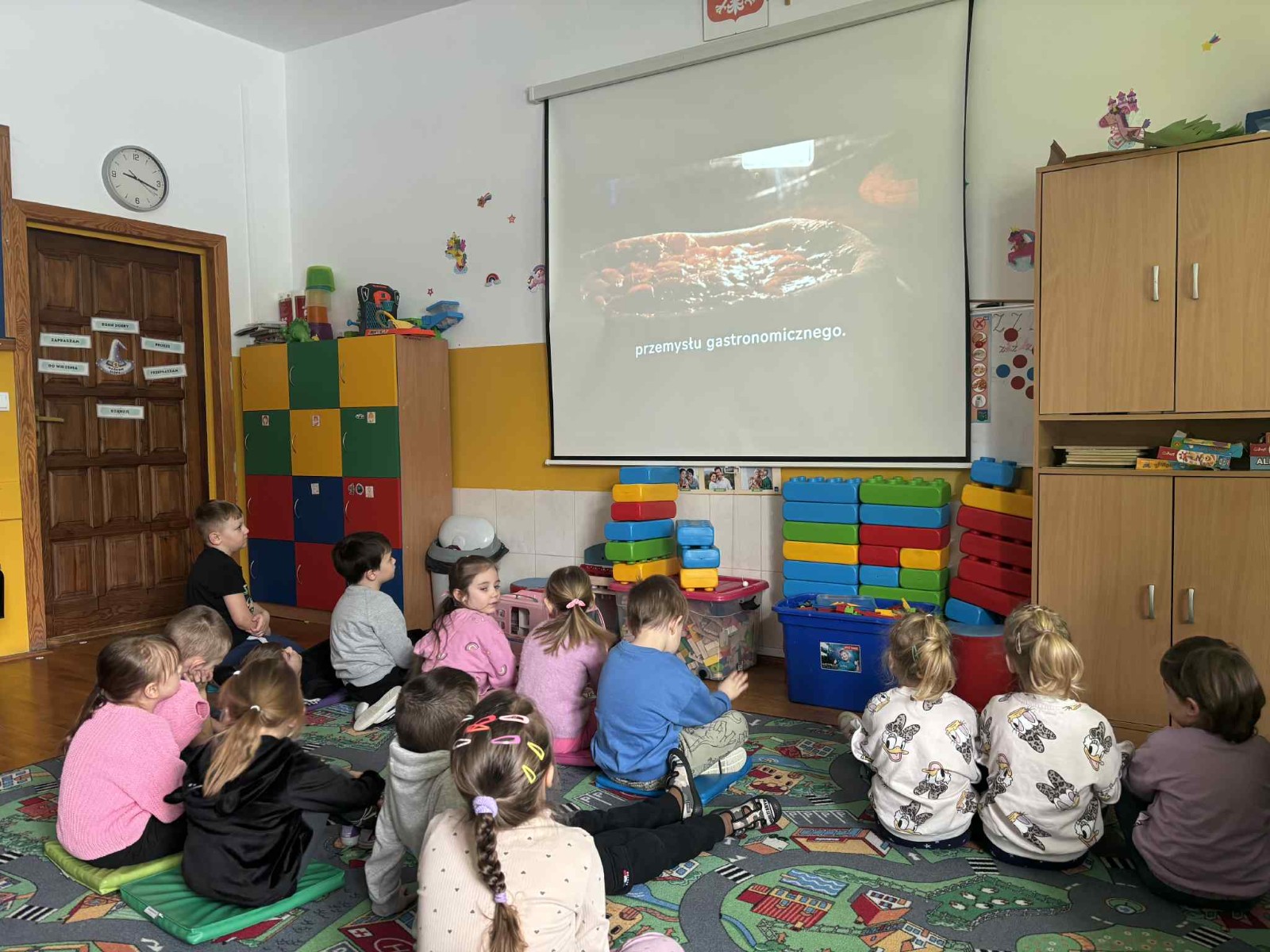 Przedszkolaki oglądają film edukacyjny 'jak powstaje pizza.