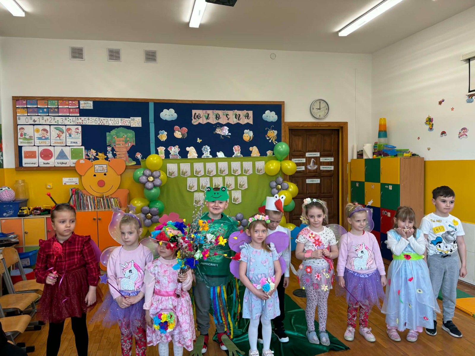 Dzieci prezentują się w wiosennych strojach.