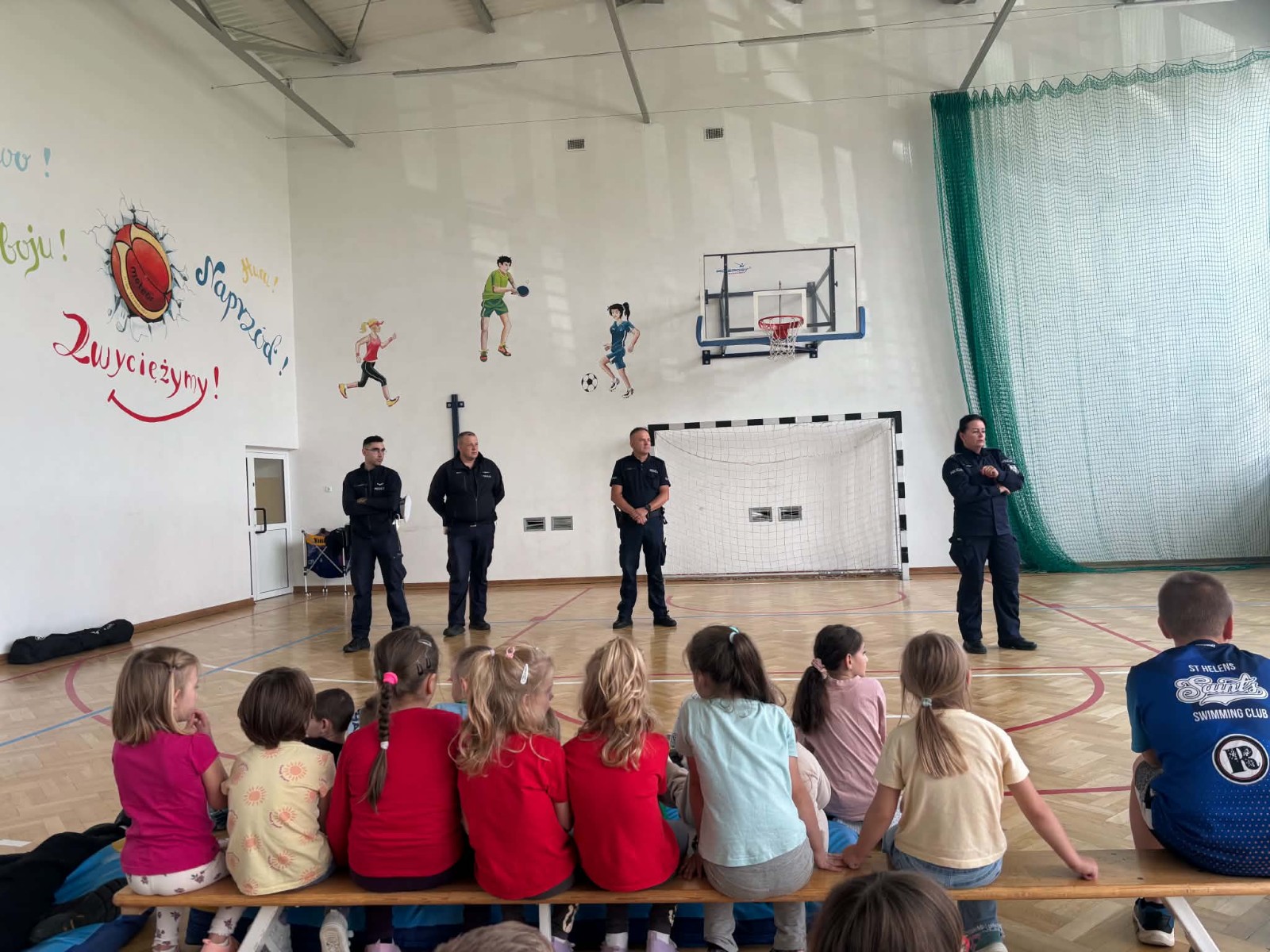Funkcjonariusze policji prowadzą pogadankę w szkole na temat bezpieczeństwa.