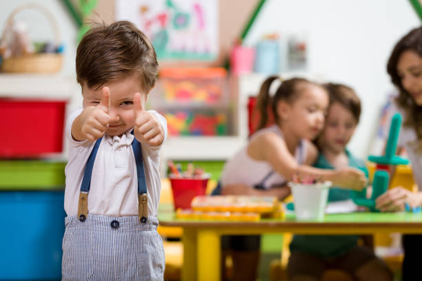 Dzieci spędzają aktywnie czas w przedszkolu, w tle zadowolony chłopiec.