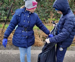 Uczniowie klasy 4 sprzątają teren niedaleko szkoły