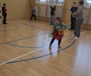 Życzliwe rozgrywki sportowe – uczniowie klasy pierwszej bawią się ze starszymi uczniami w sali gimnastycznej