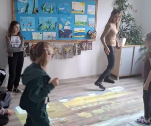 Życzliwe gry na interaktywnej podłodze – uczniowie klasy trzeciej i siódmej z panią Dyrektor podczas zabawy