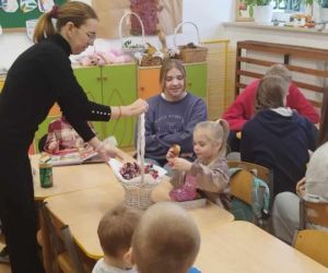 Jedna z mam z Rady Rodziców rozdaje dzieciom słodki poczęstunek