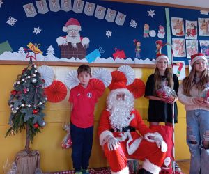 Mikołaj wręcza prezenty dzieciom