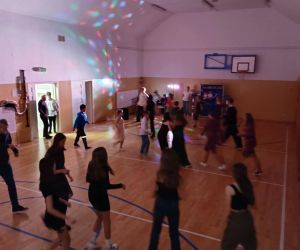 Uczniowie klas starszych w sali gimnastycznej podczas grupowego tańca