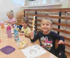 Trzy dziewczynki przy stole podczas poczęstunku