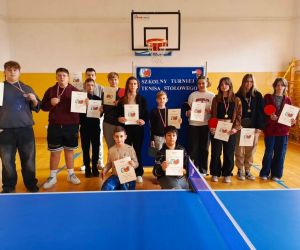 Chłopcy i dziewczęta trzymają dyplomy i medale pamiątkowe