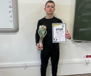 Uczeń trzyma dyplom i puchar