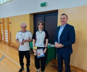 Pan Wójt, pan dyrektor szkoły w Mienianach oraz uczennica trzymająca puchar i dyplom za zdobycie drugiego miejsca
