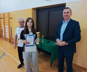 Pan Wójt, pan dyrektor szkoły w Mienianach oraz uczennica trzymająca puchar i dyplom za zdobycie pierwszego miejsca