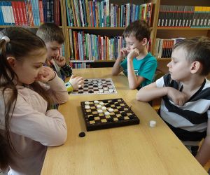 Uczniowie klas młodszych podczas rozgrywek warcabowych