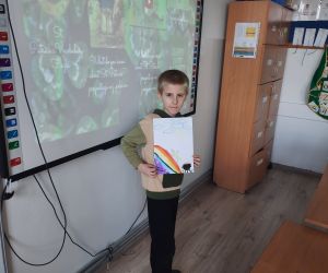 Uczeń trzyma pracę wykonaną z okazji dnia świętego Patryka
